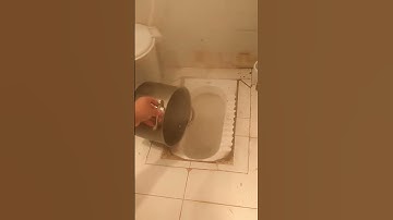 The process of pouring a pore of caustic soda into a floor toilet to get rid of a clog