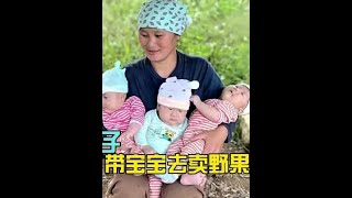 英子不辞辛劳，背着孩子和野果在路边售卖