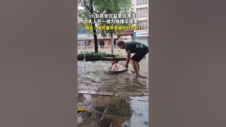 小女孩坐在盆裏玩漂流，大人在一旁為她撐傘遮雨。網友：她的童年有被好好守護。#shorts #暖心