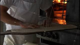 Chefs Skillfully Preparing a Delicious Pizza with Fresh Cheese in an Authentic Rustic Oven