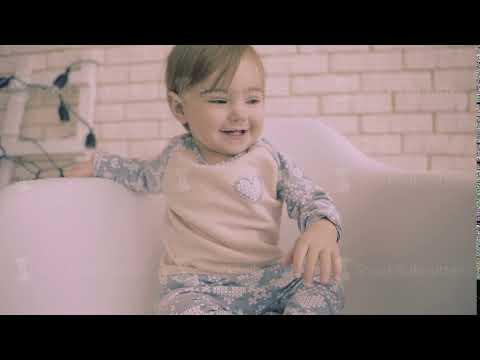 Cheerful little brunette baby girl sitting on white chair with smile slow motion