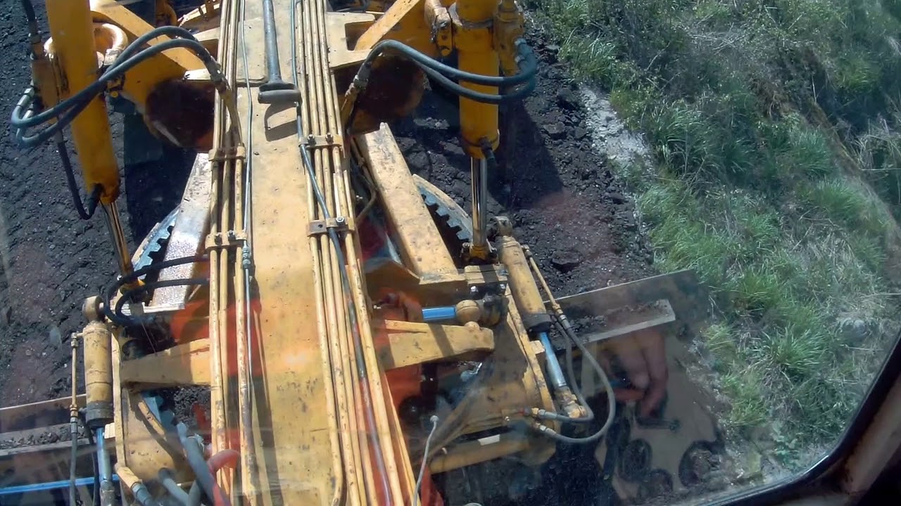 Równiarka DZ, rozgarnianie kory asfaltowej.