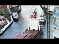 Tugboats Bringing A Cargo Ship Into The Miami River