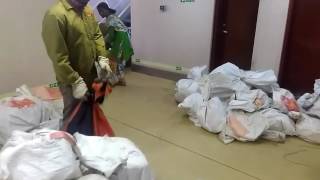 Two people loading bulk mail bags to Lakshadweep