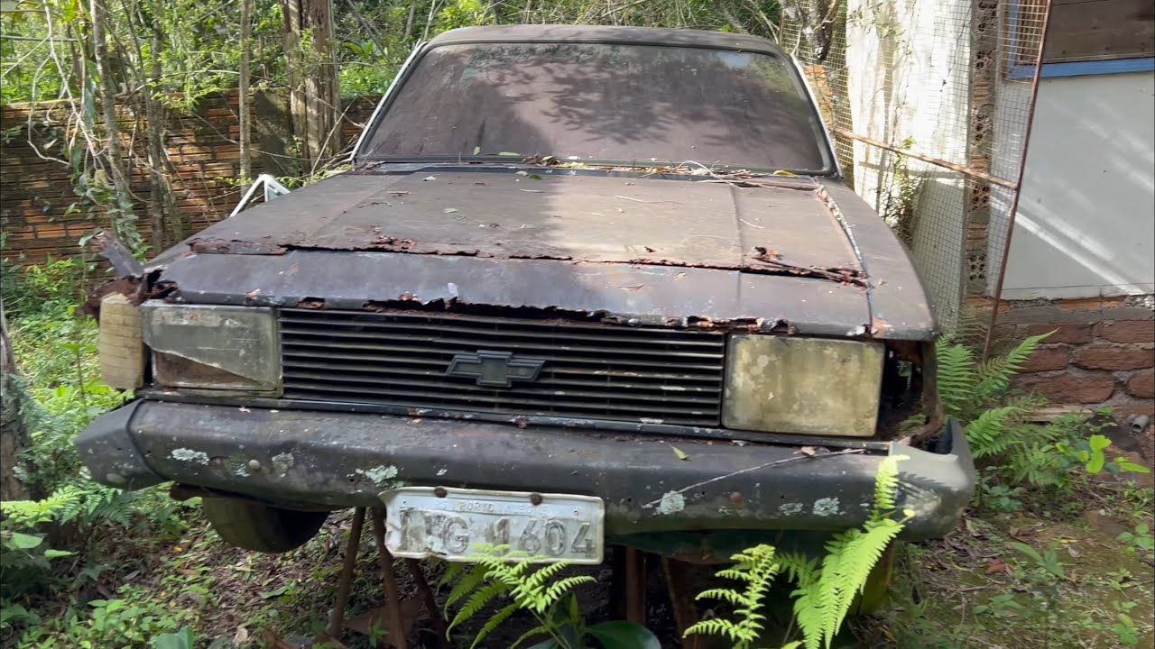 Дом с заброшенными редкими автомобилями.