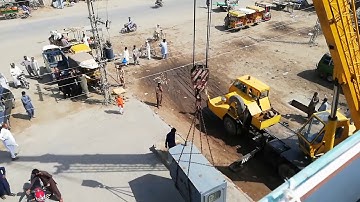 The heavy generator is being lifted by the mobile crane.