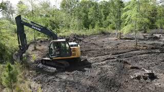 130 excavator clearing pine stumps