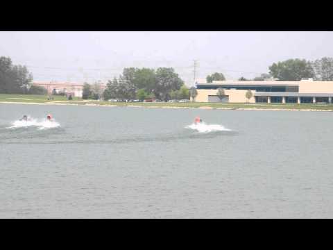 A clip of APBA powerboat racing at Lake Andrea, Pleasant Prairie, WI. My camera can record HD720, but when in video mode it doesn't have auto-focus. That's just how Nikon made the D5000. (I think they fixed that with the D5100, but I'm not 100% sure.) I do my best to keep it clear, considering I had to use an LCD with glare on it in order to compose the shot. These races are neat, because you can get close enough to smell the 2-cycle outboard fuel. This vantage was a little further out, but a had a better view of the action. (Nobody standing up in the way, etc.) From what I understand, they only race the boats on Lake Andrea two times a year. And these racing events are the only time they allow powerboats on the lake. (I suppose you could use an electric trolling motor, but it's nothing that could get a boat moving. Outside of these events, the fastest thing allowed on the lake are wind-surfers.) The rest of the racing events are elsewhere. The weather today wasn't the worlds best, but it wasn't awful either. Still there was enough threat of rain where I decided to pull my gear and pack up early. I did get a couple of nice photos, but who wants to see a cropped and scaled down slide-show on YouTube? I'll probably put them on Picasa or elsewhere on the web. Now I'm not quite a professional here, so my tripod doesn't have a smooth pivot bearing or anything of that sort. Like my camera, it's more suited to photography than video.