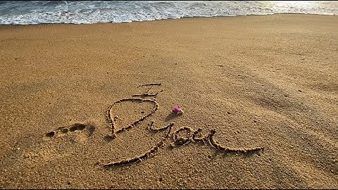 i love you message handwritten on the golden sand beach
