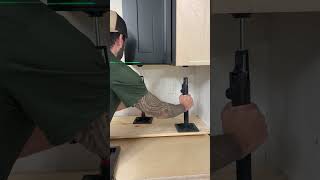 Using jacks to level the upper cabinets. #homeimprovement #tools