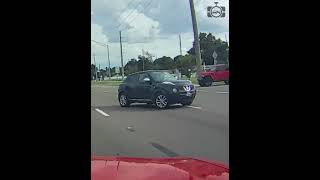 A black SUV turning the incorrect direction down a one-way street and doing a 3-point turn.