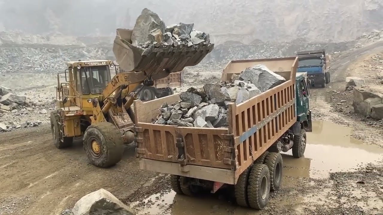 CAT 966D Loader Loading Giant Stones into Sino Truck at Worksite