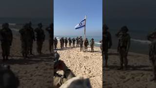 As really soldiers raise the flag on a beach in Gaza israel