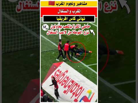 حاملي الكره بالملعب يحاولون نزع الفوطه المعمول فيها السحر من احد مسؤولي منتخب السنغال المغرب