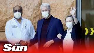 Bill Clinton unsteady as Hilary helps him out of hospital