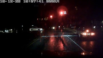 Dash cam video of a police car running a red light, nearly causing an accident