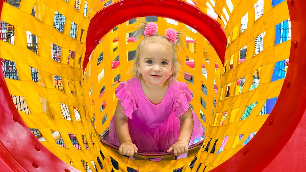 Алиса весело проводит время на детской площадке в помещении