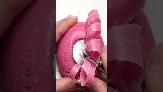 An ASMR video of cutting a round, pink, strawberry-scented soap bar using a spiral dough cutter.