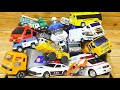 A box full of working miniature cars including a garbage truck, ambulance, police car, and bus.