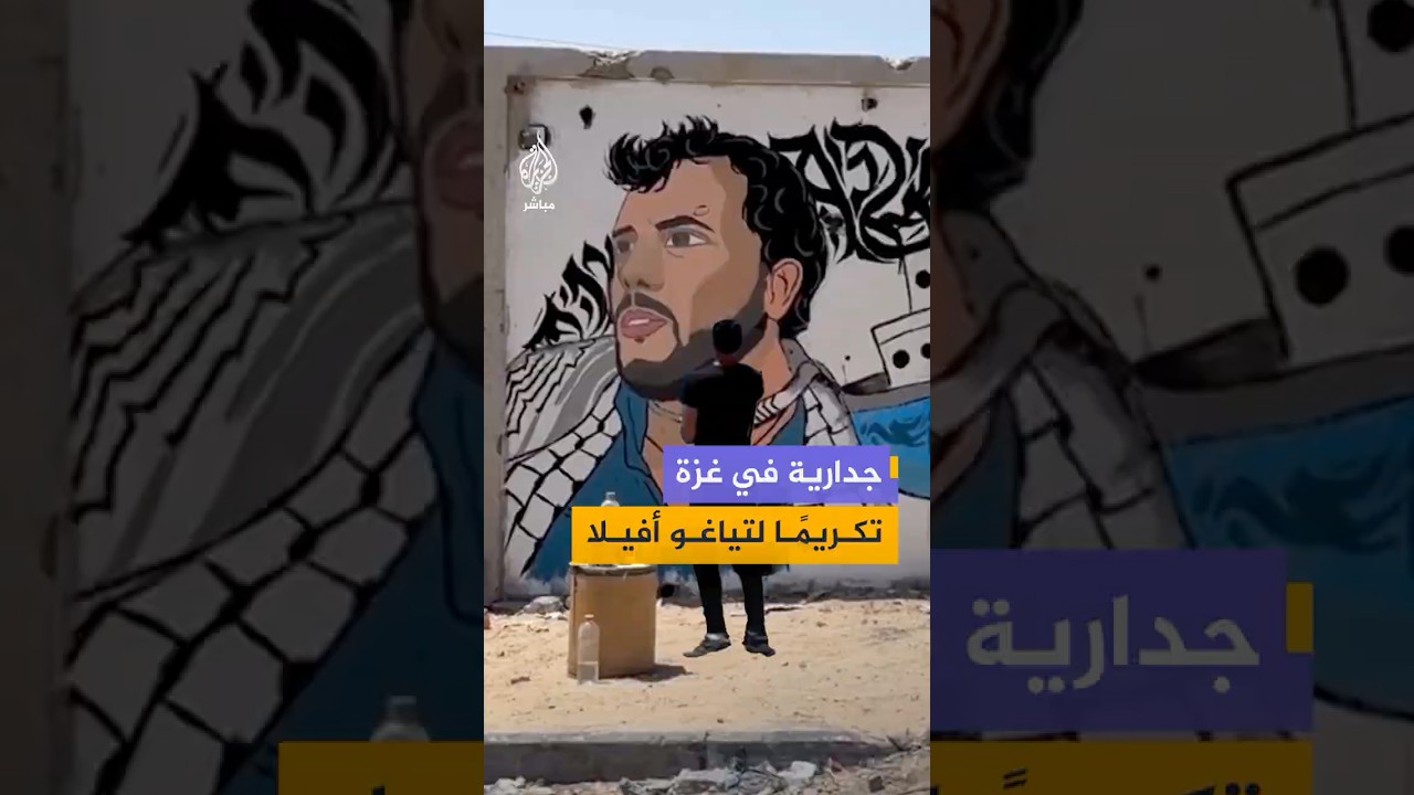 فنان فلسطيني يرسم جدارية على أحد المباني في حي الرمال بغزة تكريمًا للناشط البرازيلي تياغو أفيلا