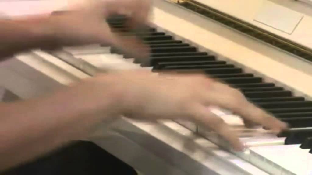 Pianist plays an upright piano equipped with double escapement action