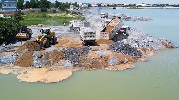 Ongoing road construction involves using a wheel loader to push and move stones into the deep water!