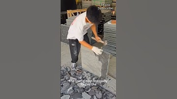 Young man forging a rock slab by hand with a chisel and hammer