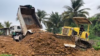 New project Dump truck 5 tons and Old bulldozer Komatsu pushing dirt for grow crops behind house