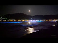 夜光虫が光る海と月