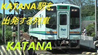 KATANA駅を出発する列車とKATANA駅前の踏切を通過するKATANA