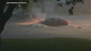 Car drives through flooded road during tornado watch in Omaha