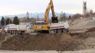 CAT 345C Excavator loading a double dump truck on a large construction site