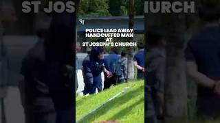 Police lead away handcuffed man at St Joseph’s Church