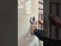 fitting a large wall tile using a suction cup tool and checking the alignment now