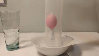 Candle on water and bottle in bowl