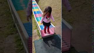 Girl goes down slide with spinners then jumps off and lands on stomach