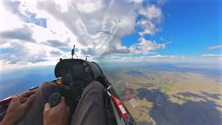 Sailplane gliding under puffy clouds in time-lapse