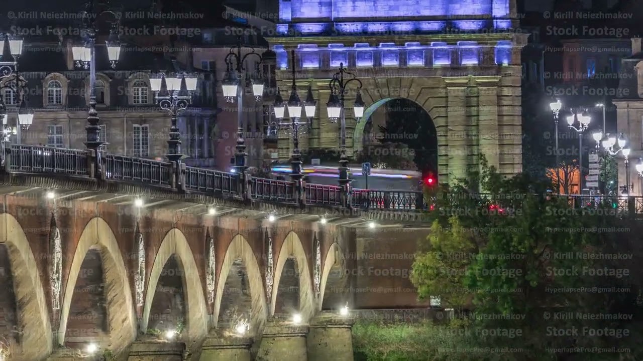 Pont de Pierre stone bridge with Porte de Bourgogne night timelapse in Bordeaux, France.