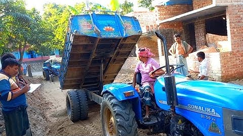 River sand is loading on tractor by excavator and unload  by digital hydraulic on charming road side