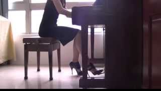 Sexy girl plays the piano in high heels and short skirt