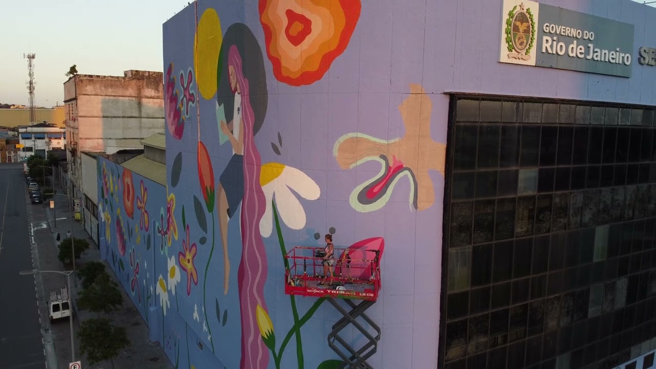 Artist Di Couto painting a building