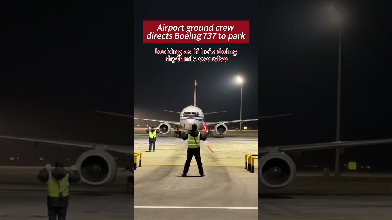 Airport ground crew directs Boeing 737 to park, looking as if he’s doing rhythmic exercise