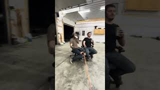 Two guys hitch a ride around garage on office chairs then crash into another chair