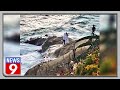 Large wave sweeps newlywed into ocean while taking pics on a rock, viral video