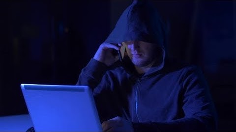 Hacker with Laptop Calling on Cellphone | Stock Footage - Videohive
