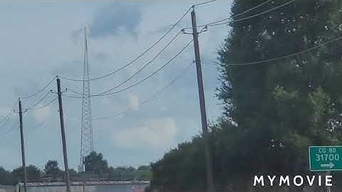 A 4 sided guyed tower and another tower with a twr strobe and LED
