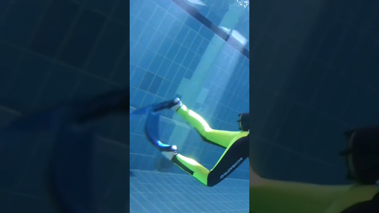 Female scuba diver scuba diving underwater in the swimming pool
