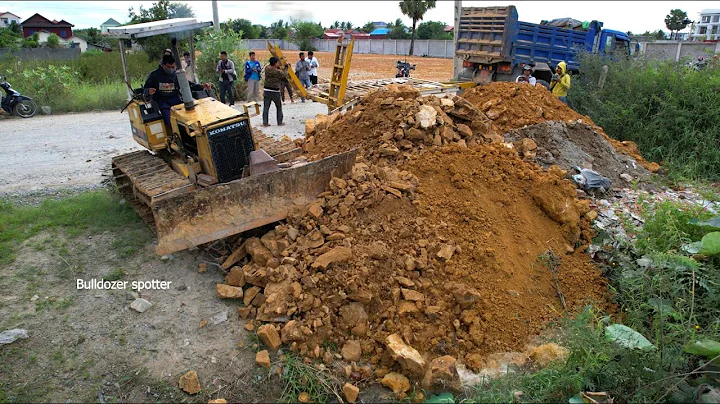 Nicely start new project landfilling build road by dump truck unloading stone with bulldozer pushing
