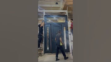 Входная дверь темного оттенка с фрамугой для частного дома.