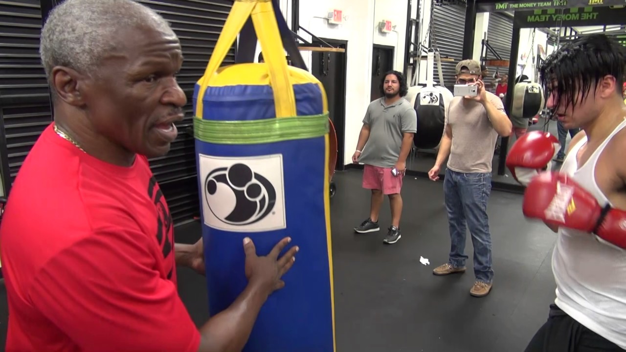 Floyd Mayweather instructing Aldo Uribe on the heavy bag inside